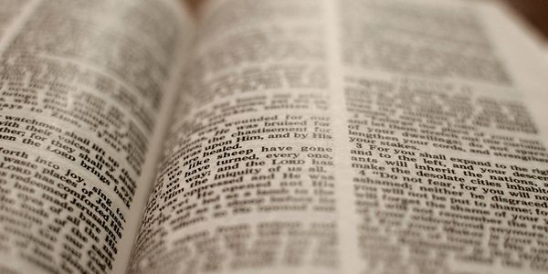 Close-up of an open book with blurred text on both pages.