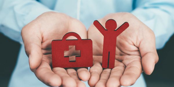 Hands holding red health and person icons.