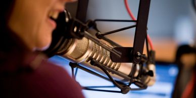 Persona hablando en un micrófono de estudio.
