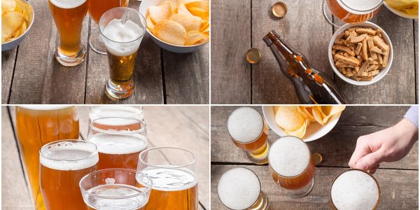 Various glasses of beer with snacks on wooden tables.
