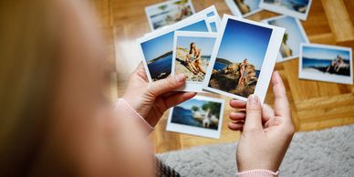 Person holding printed vacation photos.
