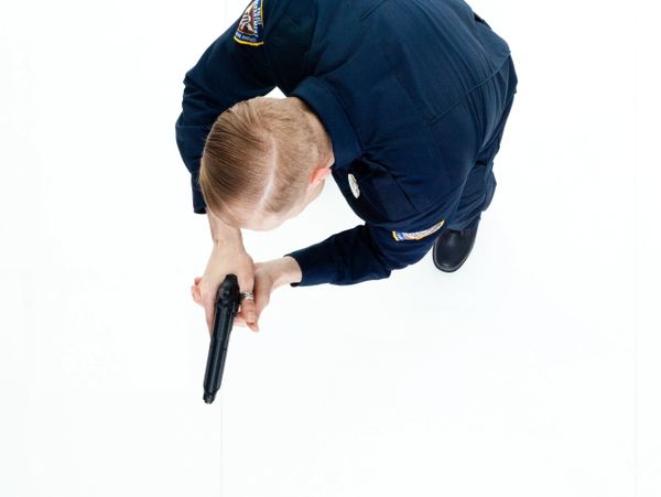 Police officer aiming a handgun, viewed from above.