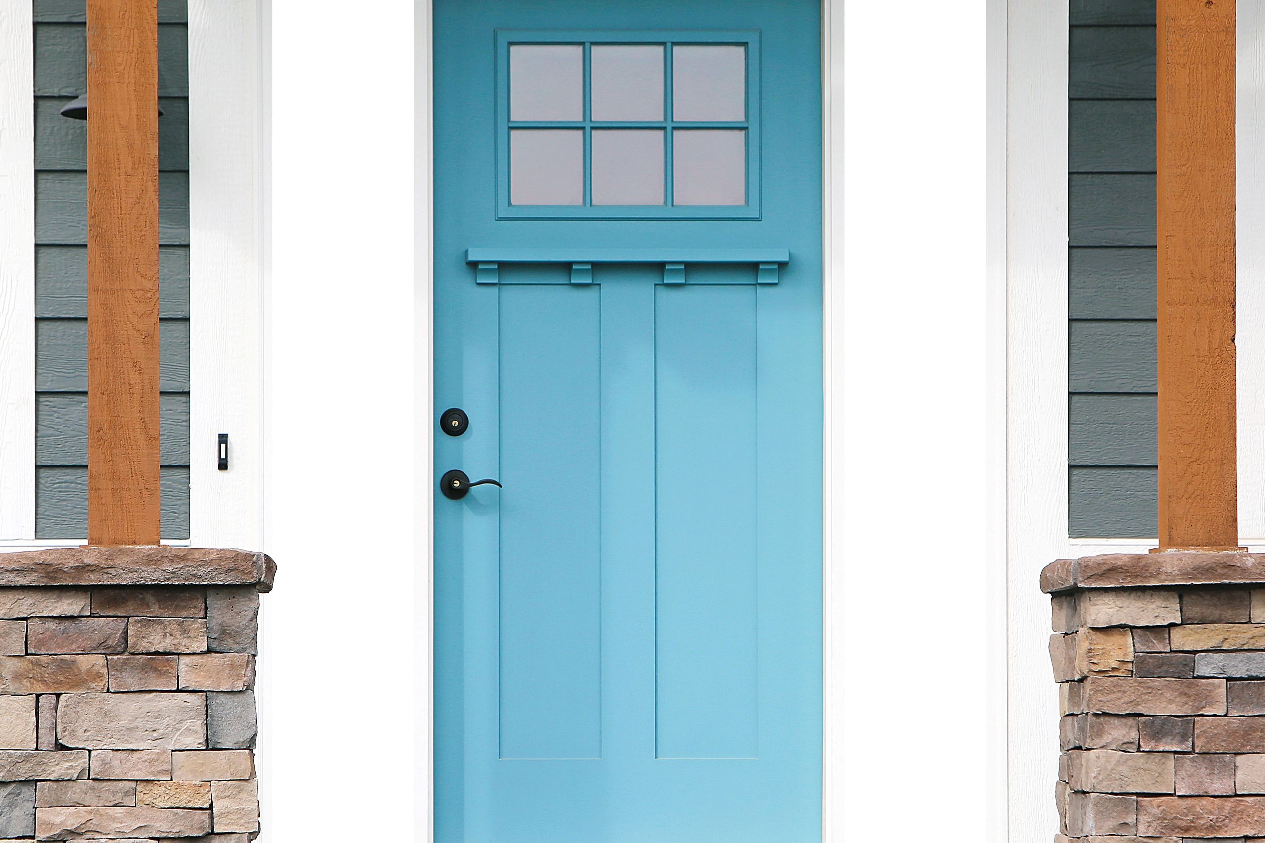 Bright blue front door with window panes and black hardware.