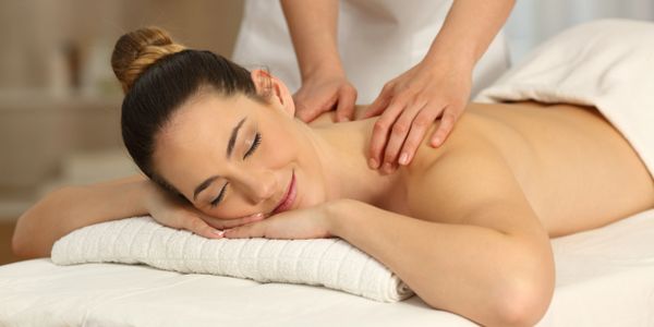 Người phụ nữ thư giãn khi được massage vai.