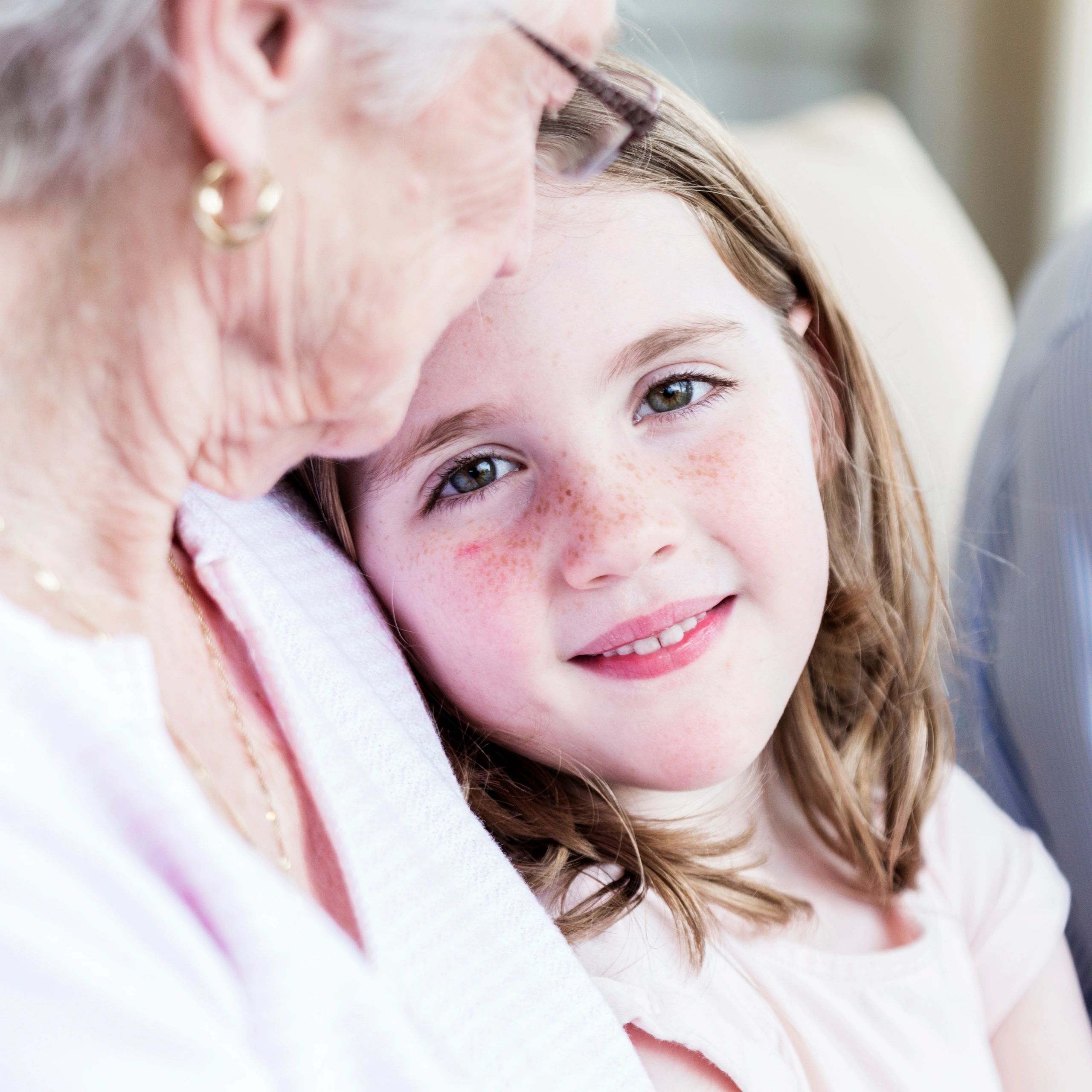 Close-up of a smiling girl with an elderly person.