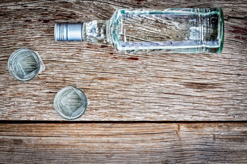 Vodka in a bottle on a wooden background. Concept: Vodka Luxury Alcohol. Copy space