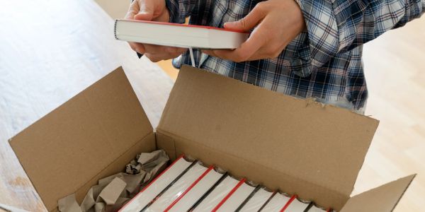 A stack of IN It Right: The Car Buying Playbook books packed inside a box