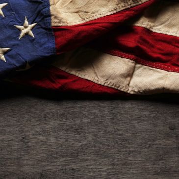 Folded American flag on a wooden surface.
