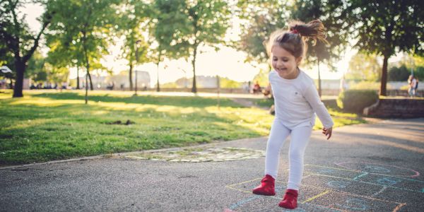 Child playing hopscotch in the park.