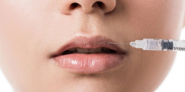 Injection being administered to lips.