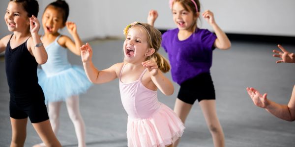 Young girls joyfully dancing in a ballet class.