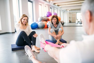 People exercising together in a bright gym.