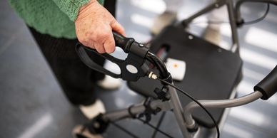 A client is walking with assistance of a 4 wheeled walker, representing equipment prescription