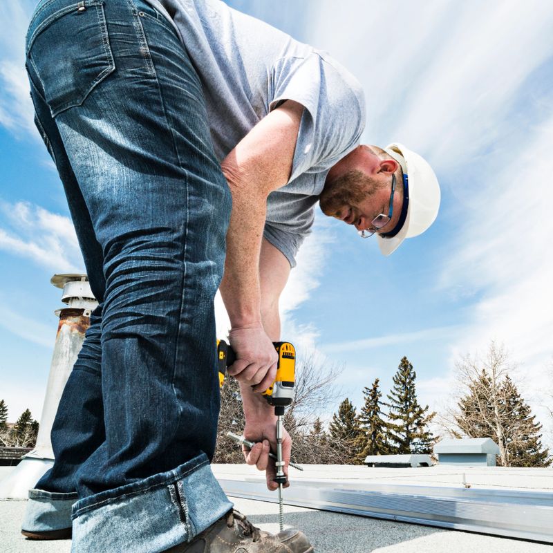 Workers installing racking and support for solar panels on a residential homes roof.