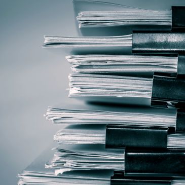Stacks of papers clipped with black binder clips.
