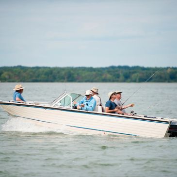 Group fishing on a boat in a lake.