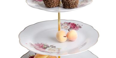 Three-tier floral china stand with assorted pastries and chocolates.