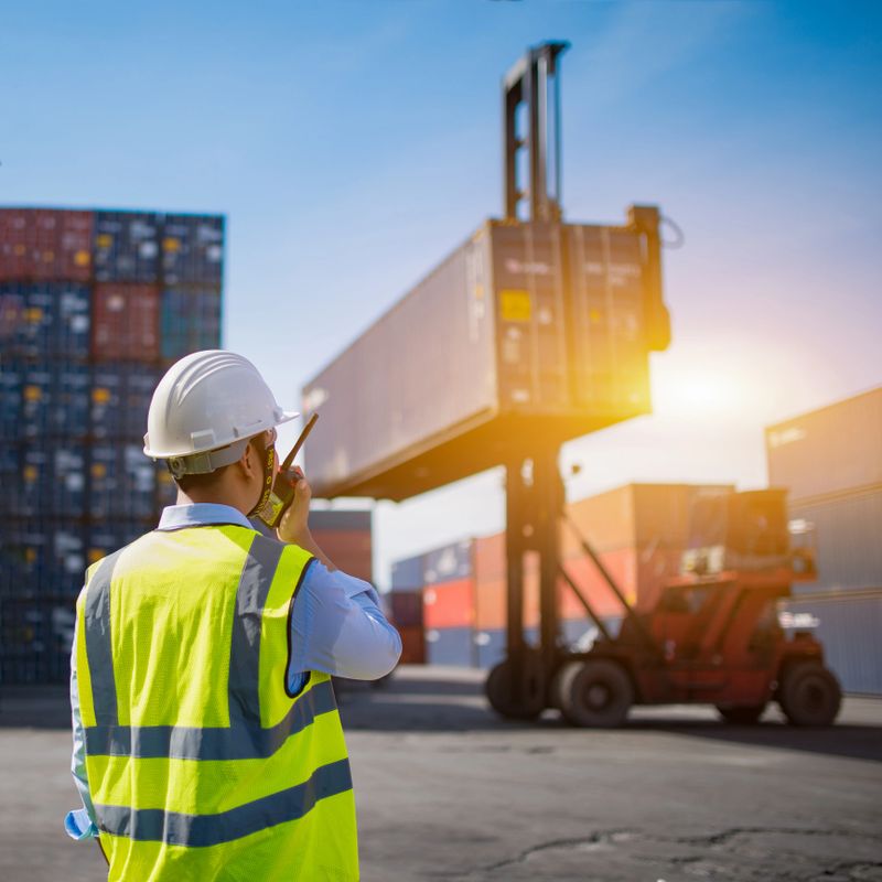 Foreman control loading Containers box from Cargo freight ship for import export