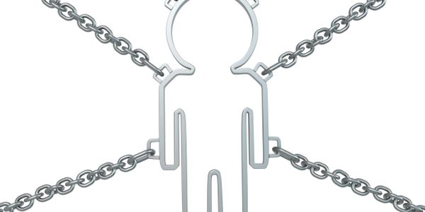 Metal figure chained from all sides symbolizing restraint or control.