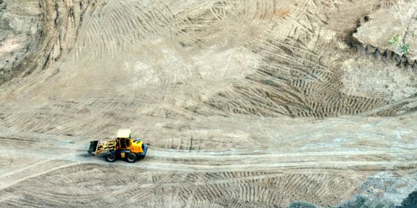 A yellow bulldozer working on a dirt construction site.