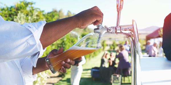 Pouring a draft beer from a tap outdoors.
