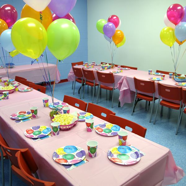 Colorful party setup with balloons and tableware.