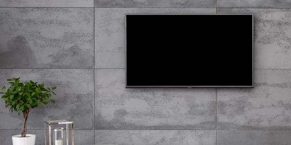 Modern living room with a wall-mounted TV and minimalistic white media console.