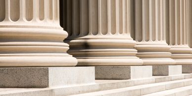Close-up of classical stone columns with fluted shafts and bases.
