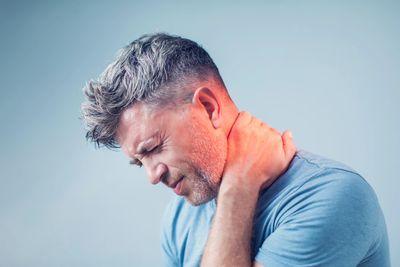 Man holding neck who needs chronic pain treatment with the West Virginia Cannabis Program 