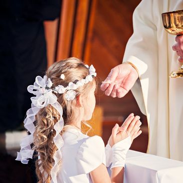Young girl receiving communion during a religious ceremony.