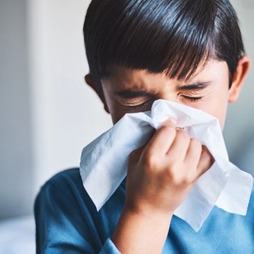 Child blowing his nose into a tissue 