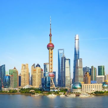 Shanghai skyline with iconic Oriental Pearl Tower and modern skyscrapers on a clear day.
