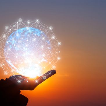 Hand holding a glowing digital globe with network connections at sunset.