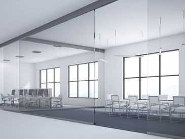 Modern office space with glass walls and minimalist furnishings.