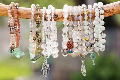a single branch elevated with various natural crystal bracelets dangling adorned with hamsa charms