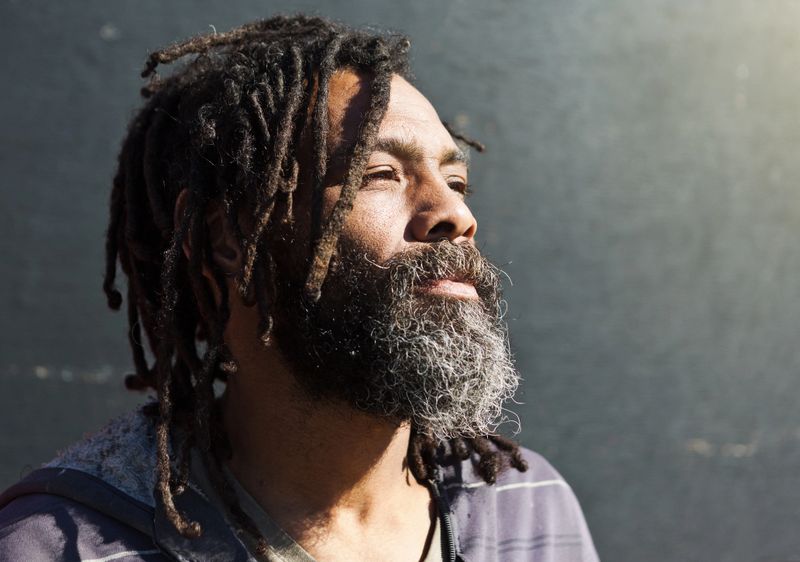 Dreadlocked man looks into the distance as if contemplating his future.