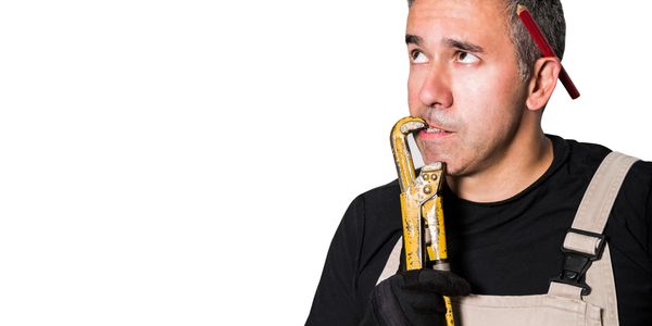 A thoughtful plumber with a wrench and pencil behind his ear.