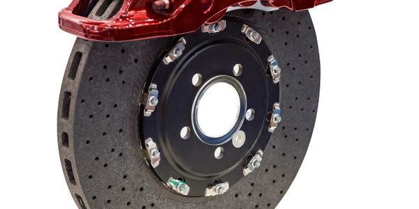 Close-up of a high-performance carbon-ceramic brake disc with red caliper.