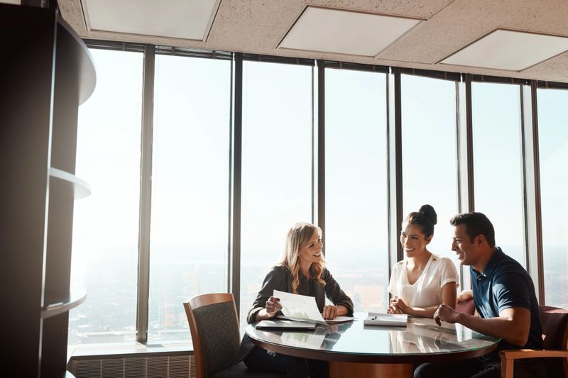 Shot of a young couple meeting with a financial planner in a modern office
