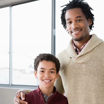 Smiling father and son indoors