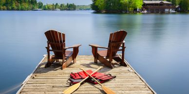 Wooden dock with Adirondack chairs overlooking calm Lake Murray SC - waterfront homes for sale