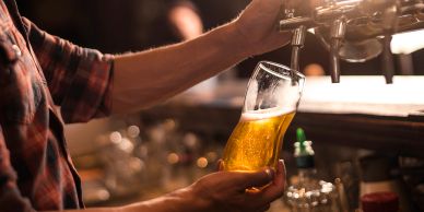 Person pouring beer from a tap into a glass.