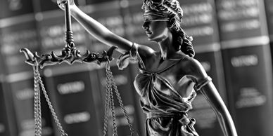 Statue of Lady Justice with scales in black and white.