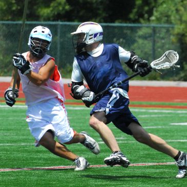 Two lacrosse players competing on the field.