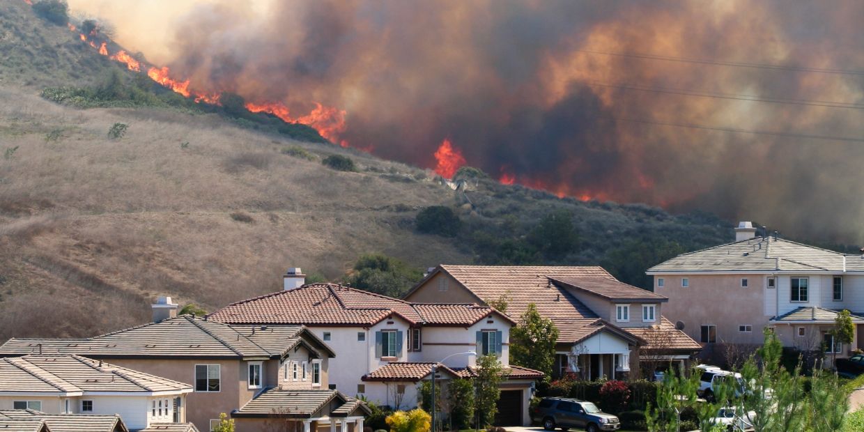 Wildfire burning near residential houses.