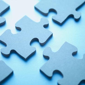 Close-up of blue puzzle pieces on a light blue surface.