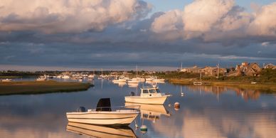 Boats floating on calm water with a cloudy sky.