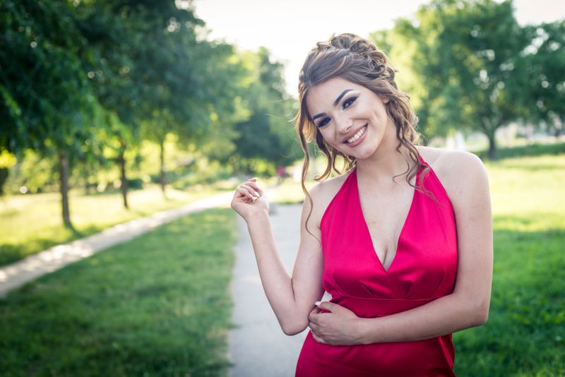 Beautiful young woman in a red dress, prom night, big night, summertime