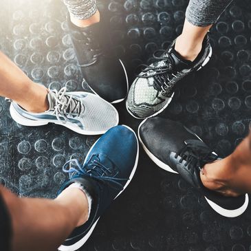 Group exercise, photo of people's gym shoes in a circle.