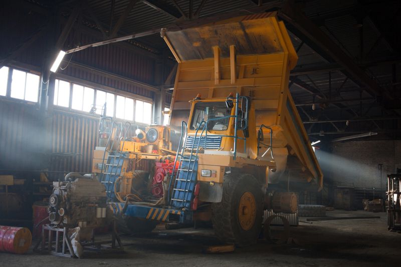 Yellow quarry dump truck in service zone